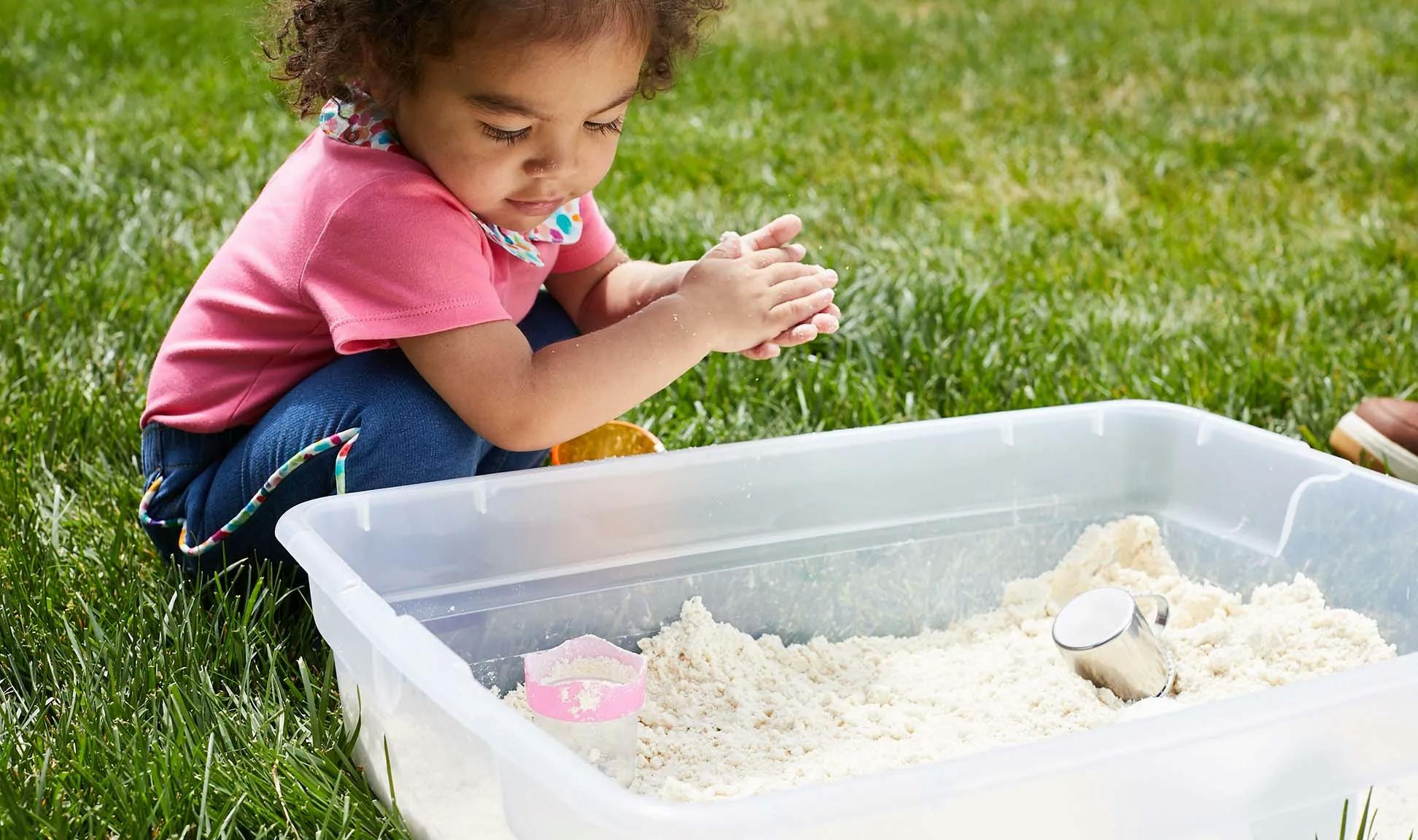 Child playing outside with sand