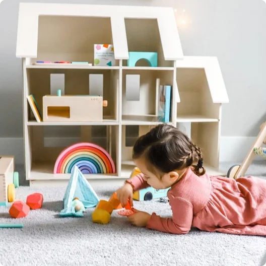 Toddler with toys from The Free Spirit Play Kit by Lovevery