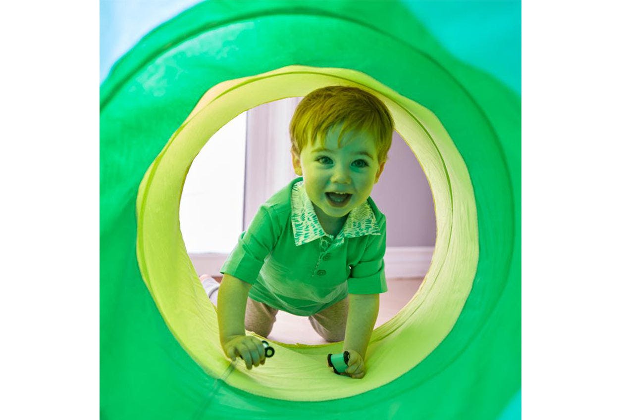 Child crawling in The Cotton Play Tunnel by Lovevery
