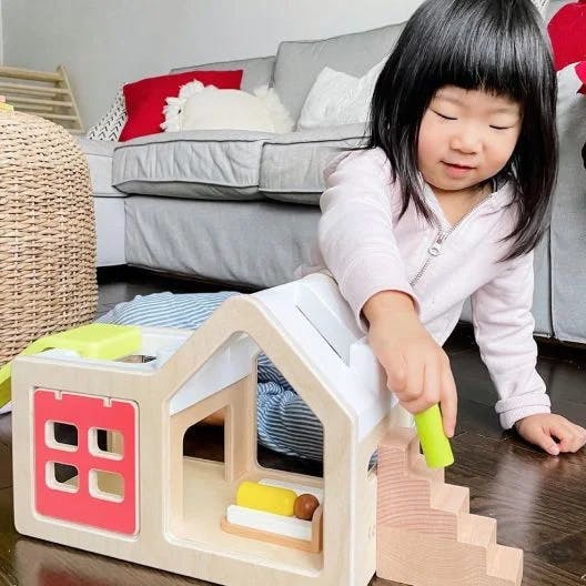 Child playing with peg people on the Modular Playhouse from The Observer Play Kit