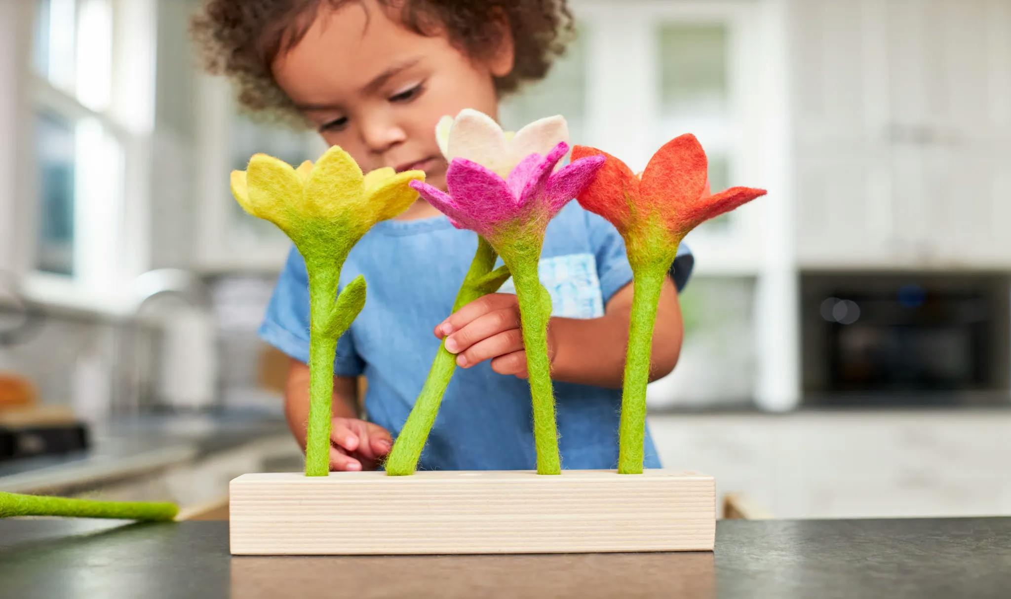 two year old playing with the felt flowers