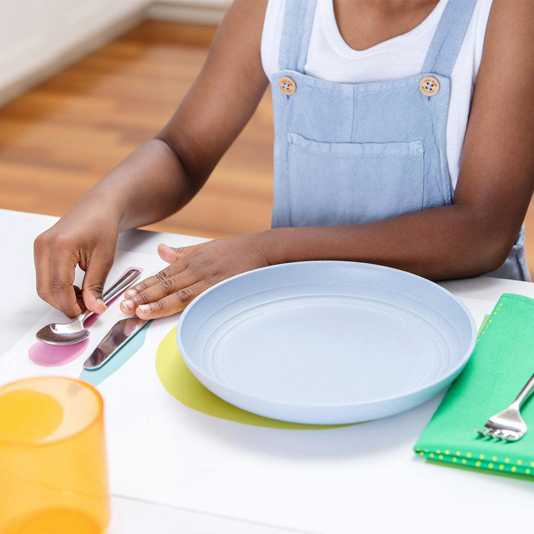 Child setting up their Montessori Placemat & Utensils by Lovevery
